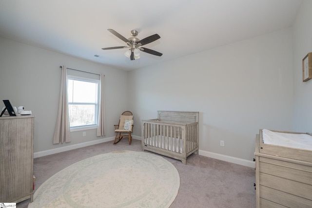 bedroom with light carpet, a ceiling fan, and baseboards