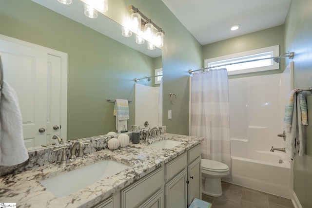 bathroom featuring double vanity, toilet, shower / bath combo, and a sink