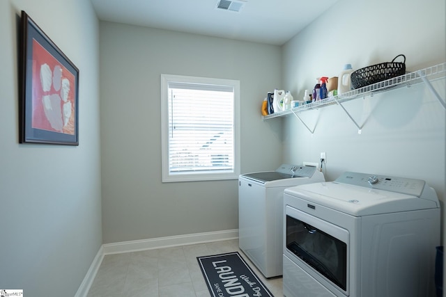 washroom with visible vents, baseboards, washing machine and dryer, laundry area, and light tile patterned flooring