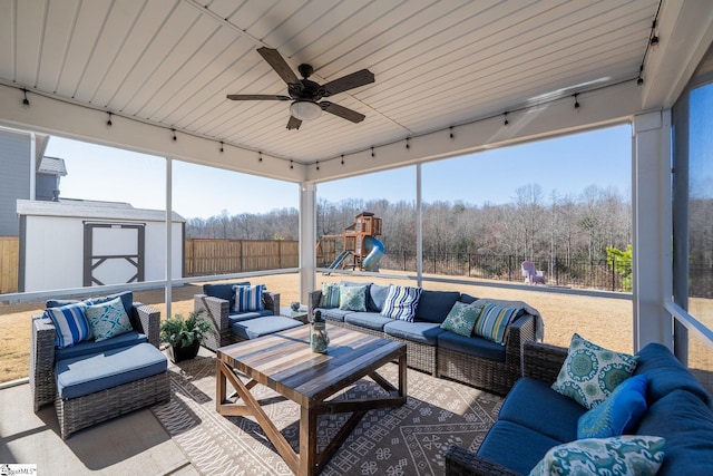 sunroom / solarium featuring rail lighting and a ceiling fan