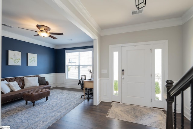 foyer entrance featuring visible vents, wainscoting, dark wood finished floors, and crown molding