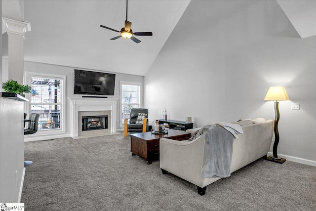 living room featuring a wealth of natural light, a fireplace with flush hearth, ceiling fan, and carpet flooring