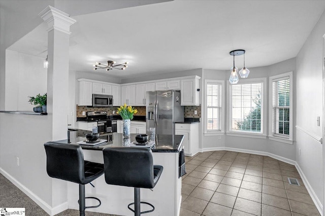 kitchen featuring decorative backsplash, dark countertops, visible vents, and appliances with stainless steel finishes