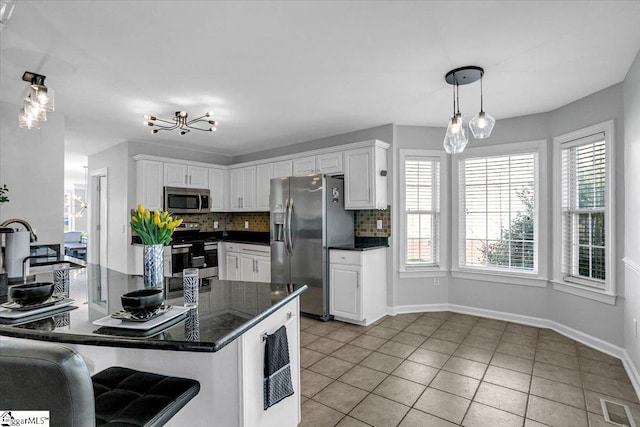 kitchen with dark countertops, visible vents, backsplash, and appliances with stainless steel finishes