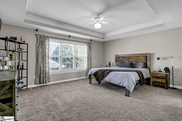 bedroom featuring a tray ceiling, carpet, and ornamental molding