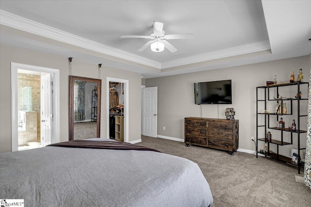 bedroom with a walk in closet, baseboards, carpet, and a tray ceiling