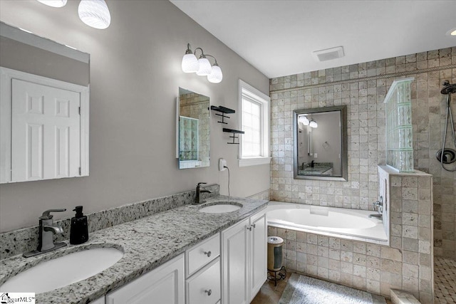 full bathroom with double vanity, a bath, a walk in shower, and a sink