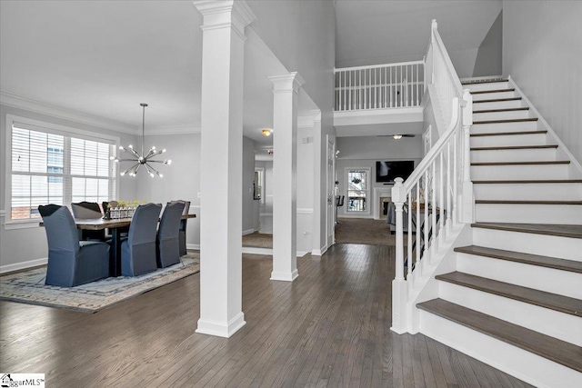 foyer entrance featuring baseboards, wood finished floors, stairs, and crown molding