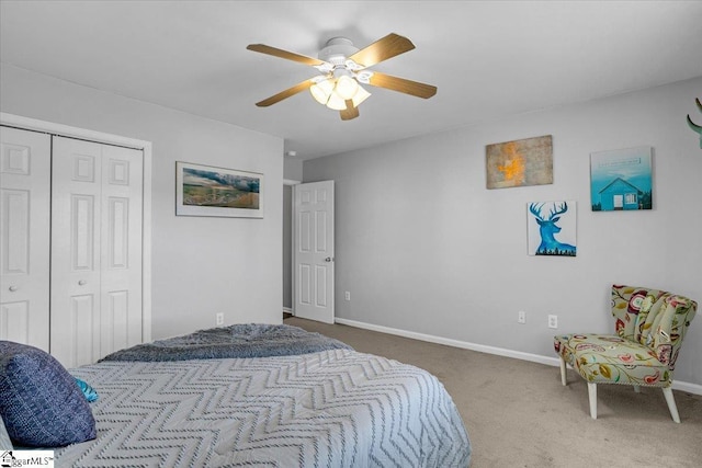 carpeted bedroom with a closet, baseboards, and ceiling fan