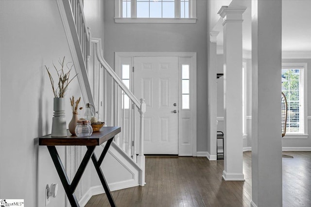 entryway with stairs, baseboards, dark wood-style flooring, and ornate columns