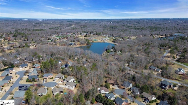 drone / aerial view featuring a residential view, a view of trees, and a water view