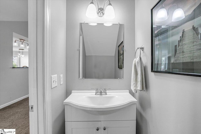 bathroom with baseboards, a chandelier, and vanity