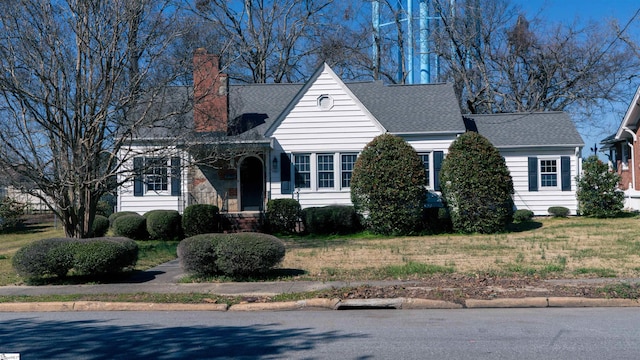 view of front of property featuring a chimney and a shingled roof