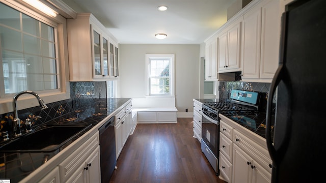 kitchen with black appliances, glass insert cabinets, dark wood-type flooring, white cabinetry, and a sink