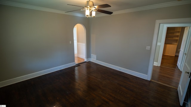 spare room featuring arched walkways, dark wood-type flooring, a ceiling fan, and ornamental molding