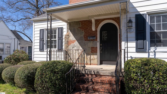 entrance to property featuring brick siding