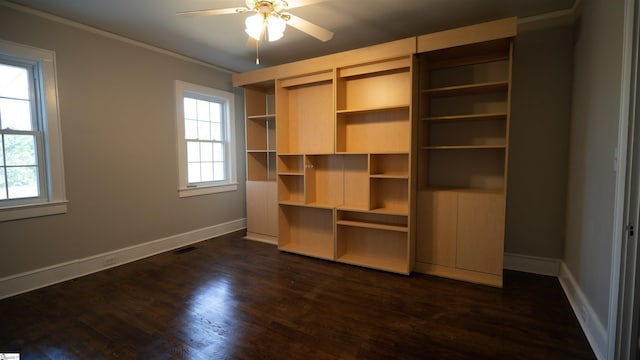 unfurnished bedroom featuring dark wood-type flooring, crown molding, baseboards, and visible vents