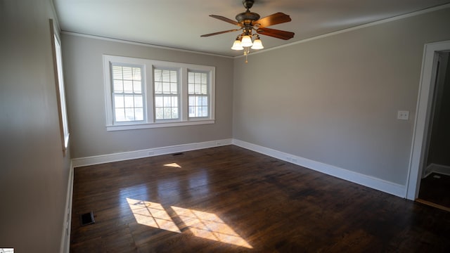 empty room with crown molding, baseboards, and dark wood-type flooring