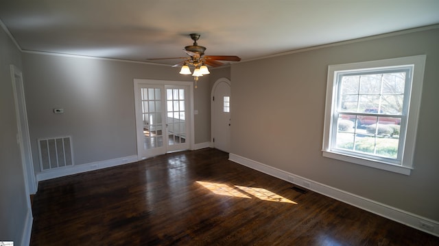 unfurnished room featuring dark wood-style floors, baseboards, visible vents, and ornamental molding