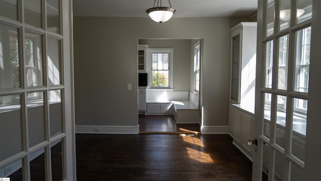 entryway with dark wood-type flooring and baseboards