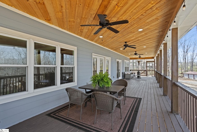 deck with outdoor dining area and a ceiling fan