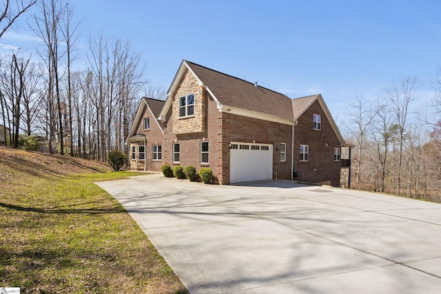 view of side of home featuring driveway, stone siding, a garage, a lawn, and brick siding