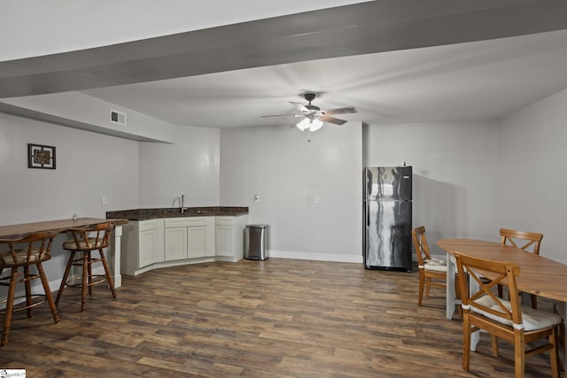 kitchen featuring visible vents, ceiling fan, dark wood finished floors, freestanding refrigerator, and a sink