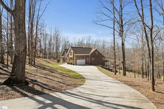 view of front facade featuring concrete driveway, an attached garage, and brick siding