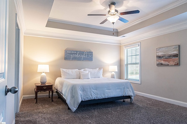 bedroom featuring baseboards, carpet floors, a raised ceiling, and crown molding