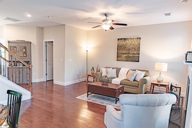 living area featuring visible vents, stairway, ceiling fan, and wood finished floors