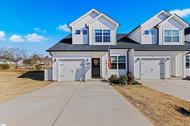 view of front of property featuring board and batten siding, a shingled roof, concrete driveway, a front yard, and an attached garage