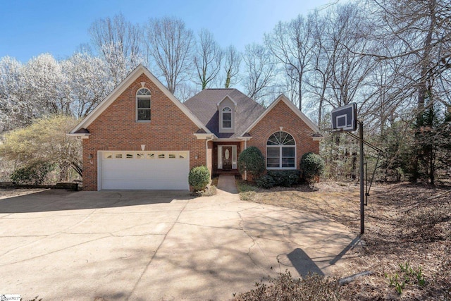 traditional-style home with brick siding, an attached garage, and driveway