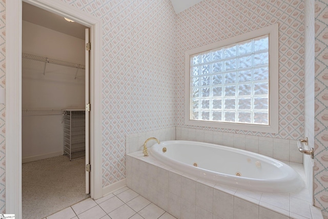 full bathroom with baseboards, wallpapered walls, a whirlpool tub, a spacious closet, and tile patterned floors