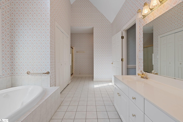 bathroom with wallpapered walls, lofted ceiling, vanity, and tile patterned floors