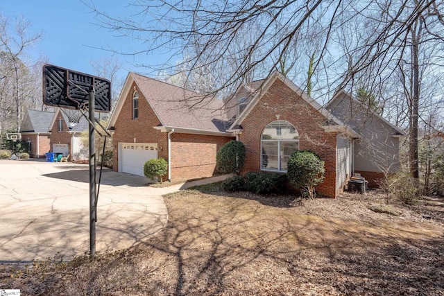 view of front of home featuring brick siding, driveway, and roof with shingles