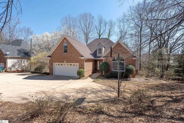 traditional home featuring concrete driveway, a garage, and brick siding