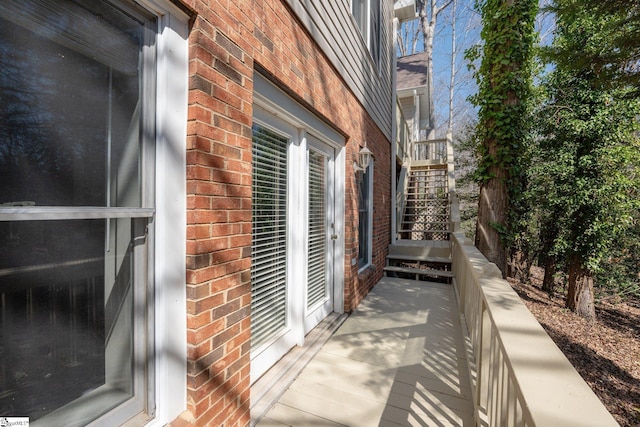 view of home's exterior featuring stairway and brick siding