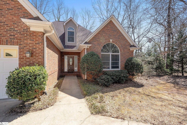 entrance to property with brick siding and a shingled roof