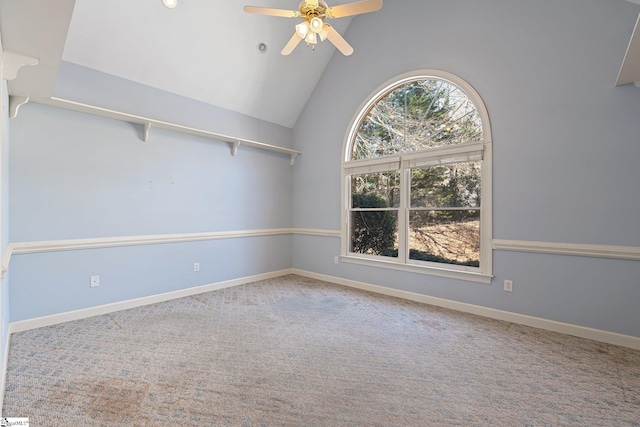 carpeted empty room featuring baseboards, high vaulted ceiling, and ceiling fan