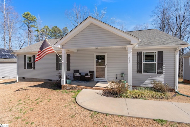 ranch-style home with crawl space, covered porch, and a shingled roof