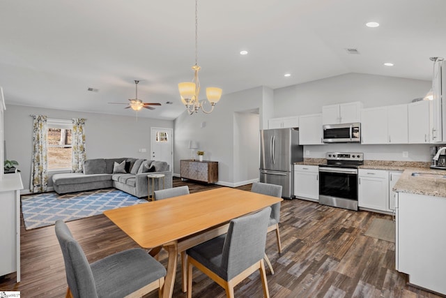 interior space with visible vents, dark wood-type flooring, ceiling fan with notable chandelier, recessed lighting, and vaulted ceiling