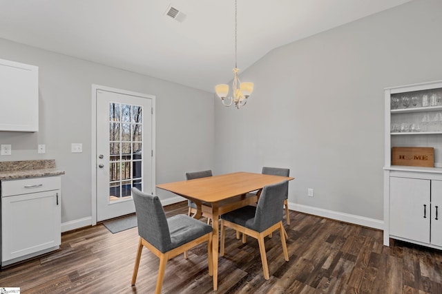 dining area with dark wood-style floors, visible vents, a chandelier, and vaulted ceiling