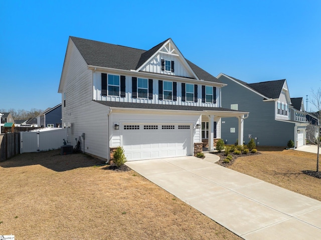 view of front of house with board and batten siding, fence, central AC unit, driveway, and an attached garage