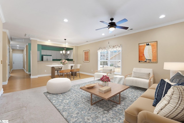 living area featuring a ceiling fan, baseboards, attic access, recessed lighting, and crown molding