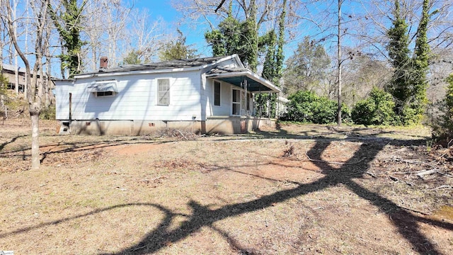 view of side of home featuring crawl space and a chimney