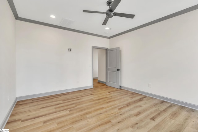 spare room featuring baseboards, light wood-type flooring, a ceiling fan, and ornamental molding