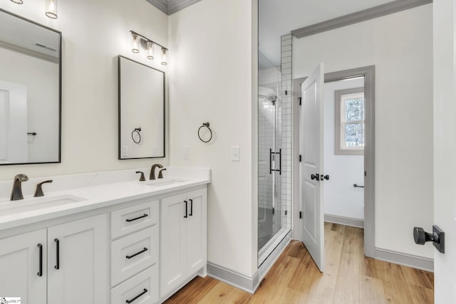 full bath featuring a shower stall, wood finished floors, and a sink