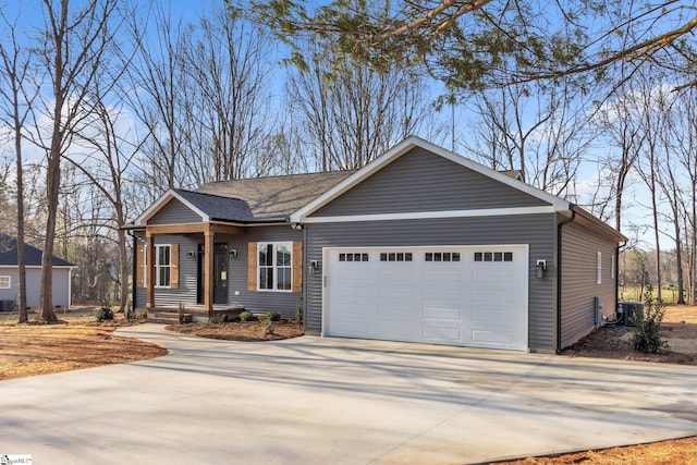 view of front of property with central AC unit, concrete driveway, and an attached garage