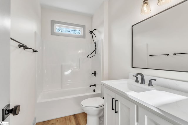 full bathroom with tub / shower combination, toilet, vanity, and wood finished floors