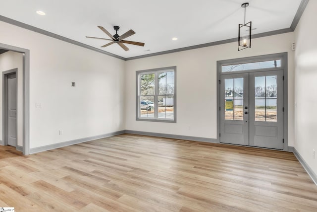 foyer with crown molding, light wood-style flooring, a ceiling fan, and baseboards